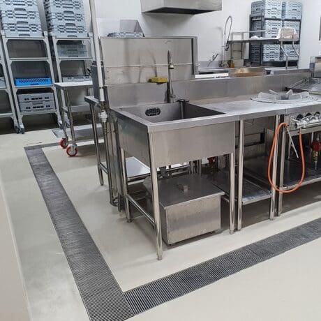 Commercial kitchen coating with a drain